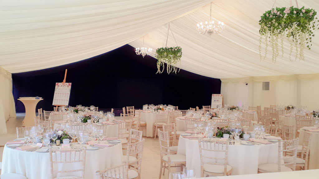 A large marquee in morning light with glass walls and a canopy entrance